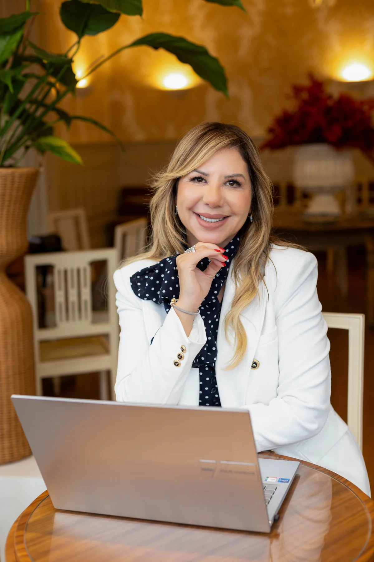 Maria Belo Fuzetti de terno branco, sentada à mesa